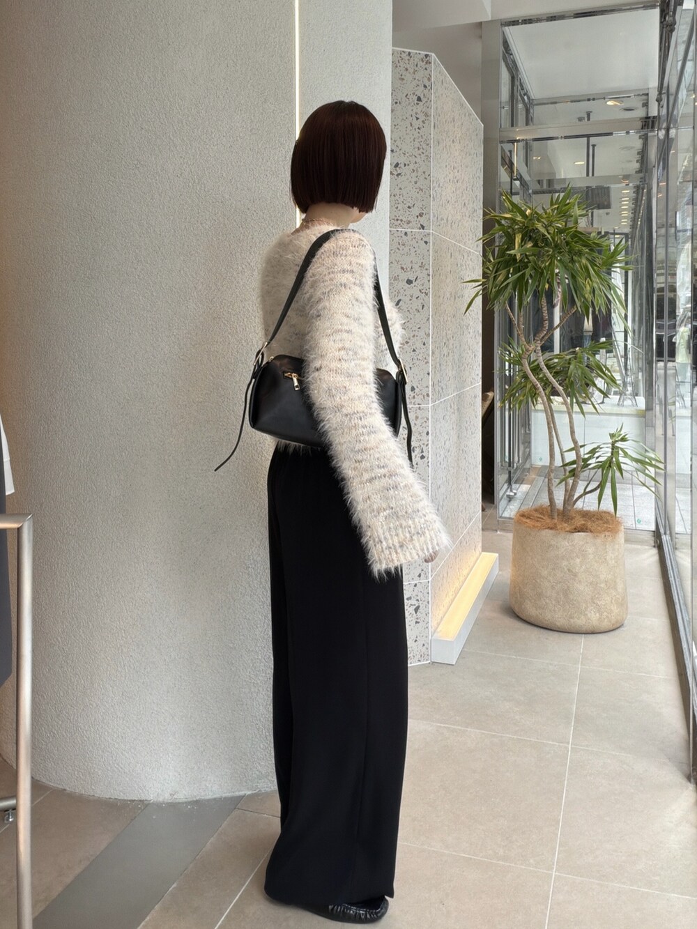 ホワイト系のカーディガン/ボレロ、ブラック系のショルダーバッグ、ブラック系のその他パンツを着用したレディースの秋コーディネートの2枚目の写真