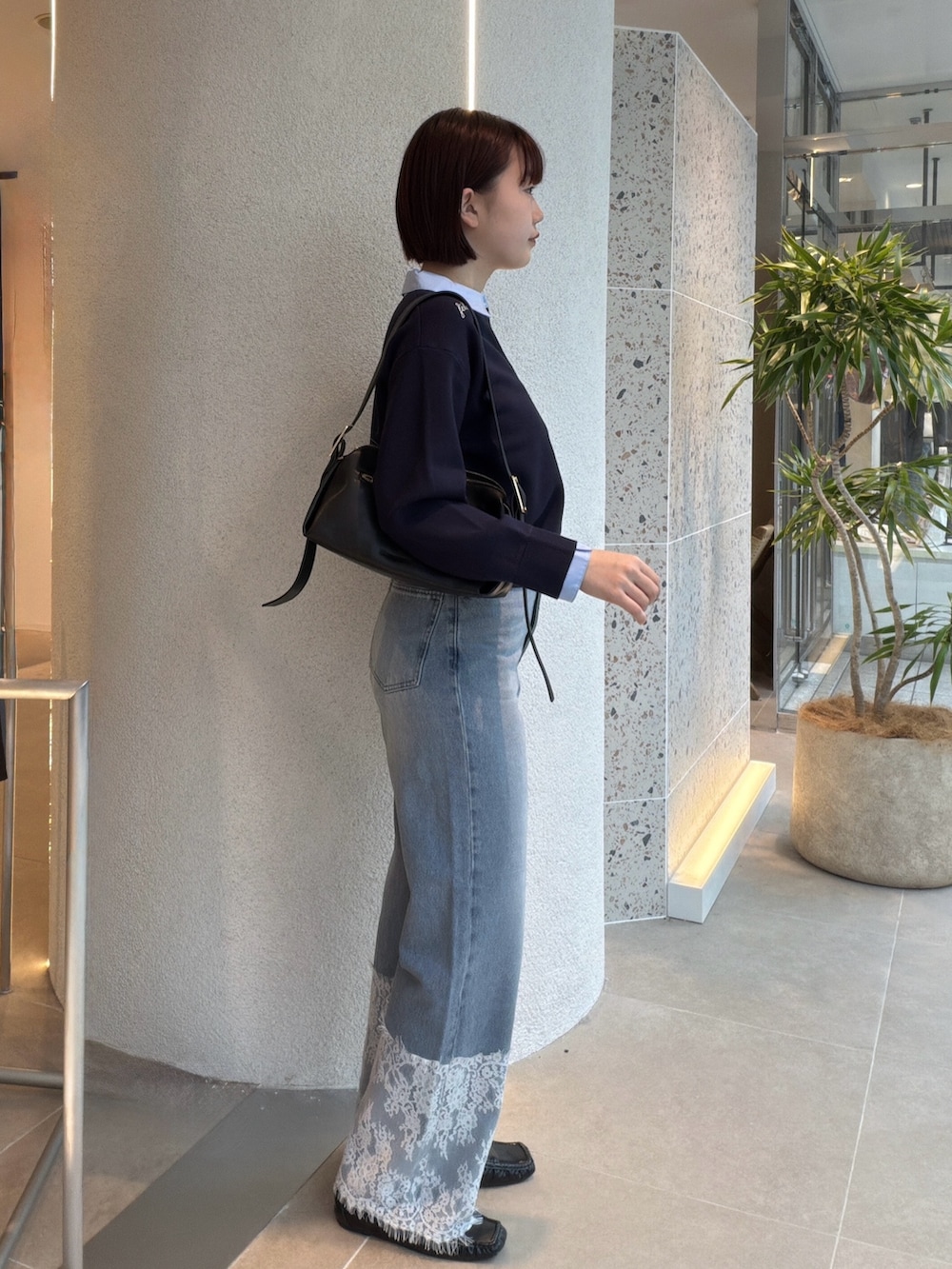 ブルー系のニット/セーター、ブラック系のショルダーバッグ、ブルー系のデニムパンツを着用したレディースの秋コーディネートの2枚目の写真