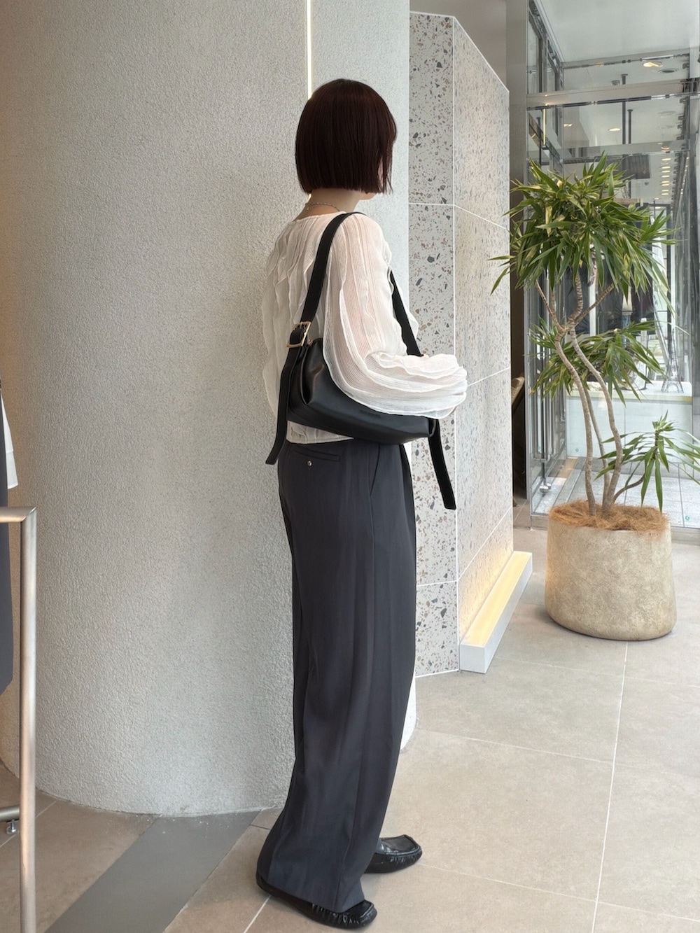 ホワイト系のTシャツ/カットソー、グレー系のその他パンツ、ブラック系のショルダーバッグを着用したレディースの秋コーディネートの2枚目の写真