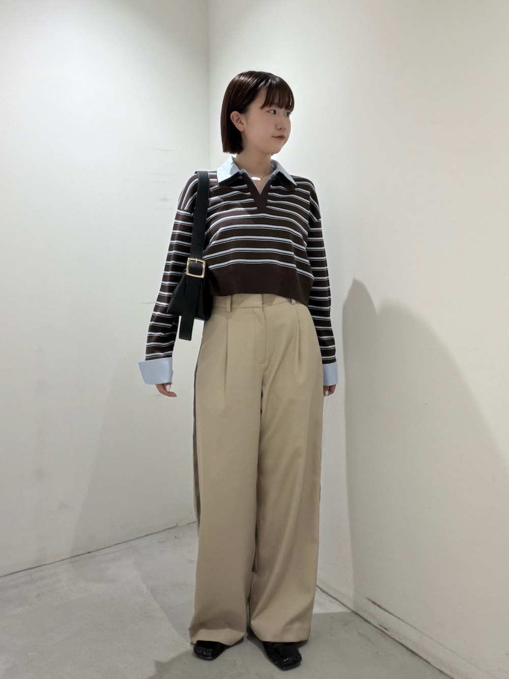 ブラウン系のニット/セーター、ブラック系のショルダーバッグ、ベージュ系のその他パンツを着用したレディースの夏コーディネートの5枚目の写真