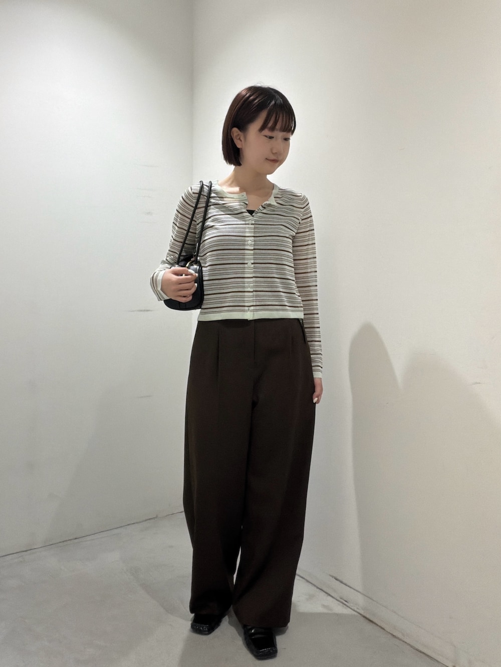 グリーン系のアンサンブル、ブラック系のボストンバッグ、ブラウン系のその他パンツを着用したレディースの夏コーディネートの5枚目の写真