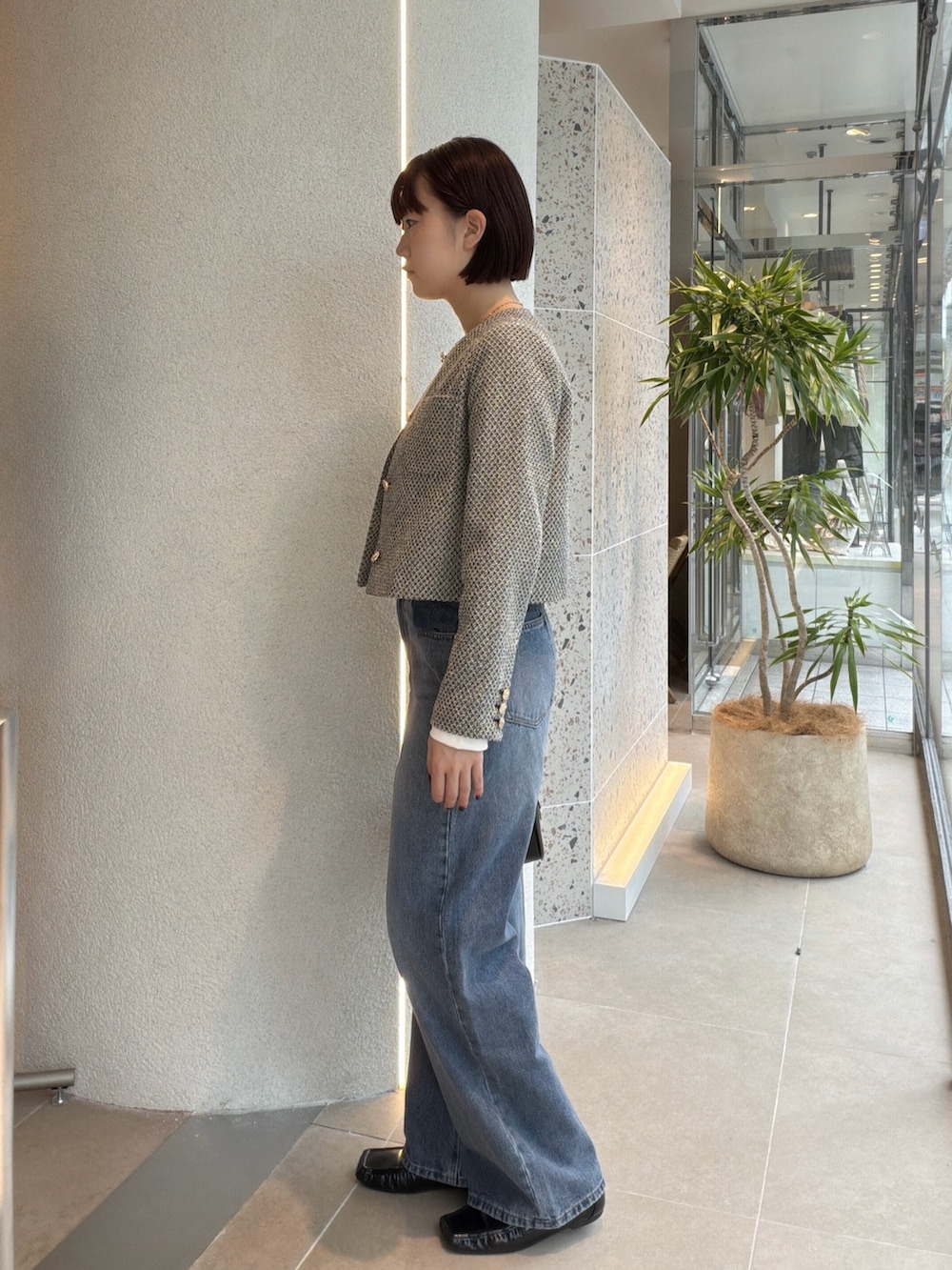 ブラック系のブルゾン、ホワイト系のTシャツ/カットソー、ブルー系のデニムパンツを着用したレディースの秋コーディネートの4枚目の写真