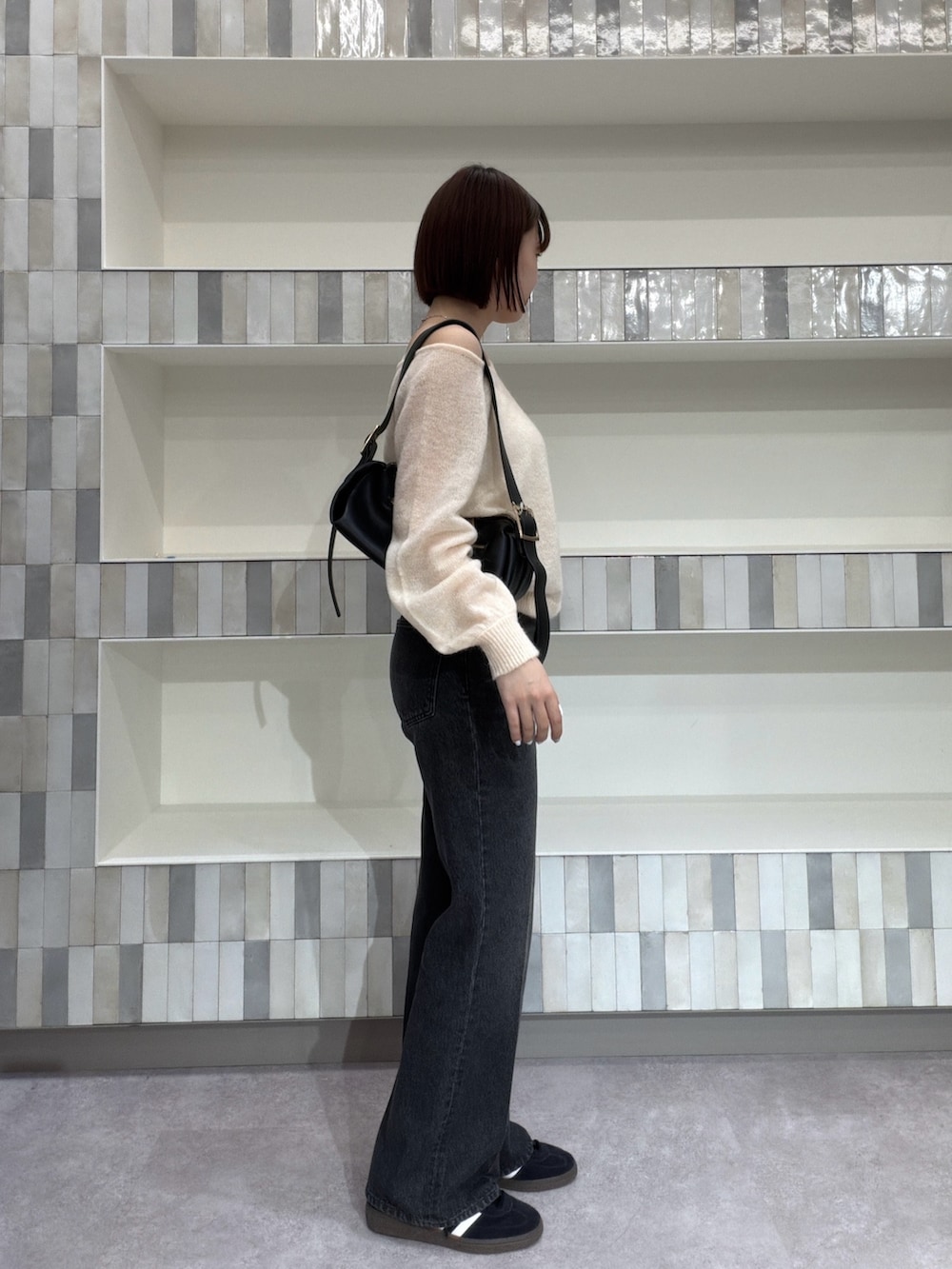 ホワイト系のニット/セーター、ブラック系のショルダーバッグ、ブラック系のその他パンツを着用したレディースの夏コーディネートの2枚目の写真