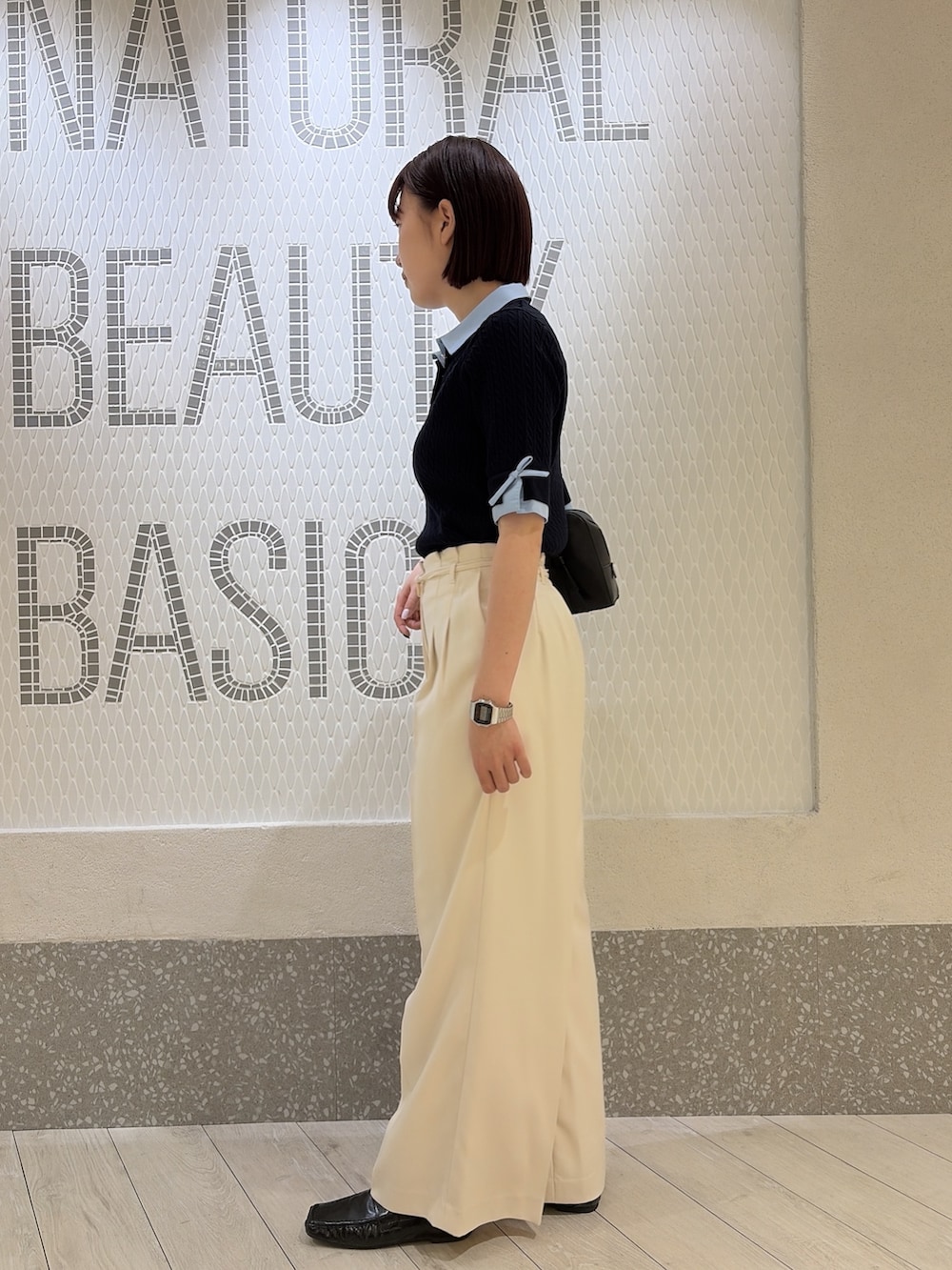 グレー系のニット/セーター、ブラック系のボストンバッグ、ホワイト系のその他パンツを着用したレディースの夏コーディネートの4枚目の写真
