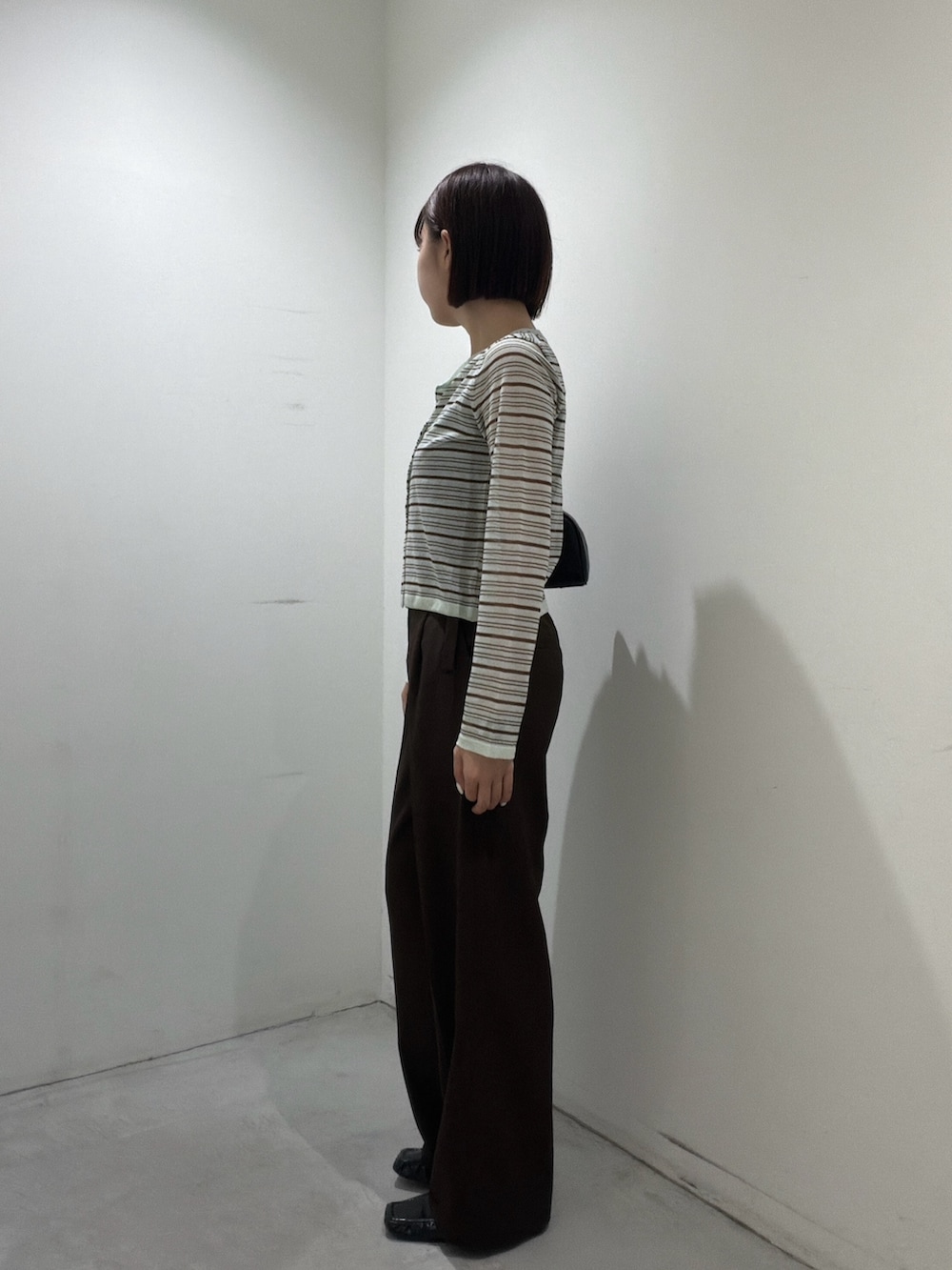 グリーン系のアンサンブル、ブラック系のボストンバッグ、ブラウン系のその他パンツを着用したレディースの夏コーディネートの4枚目の写真