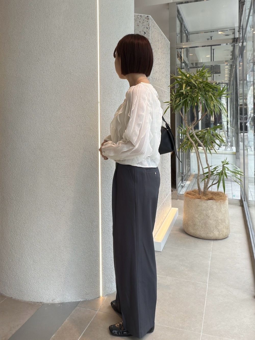 ホワイト系のTシャツ/カットソー、グレー系のその他パンツ、ブラック系のショルダーバッグを着用したレディースの秋コーディネートの4枚目の写真
