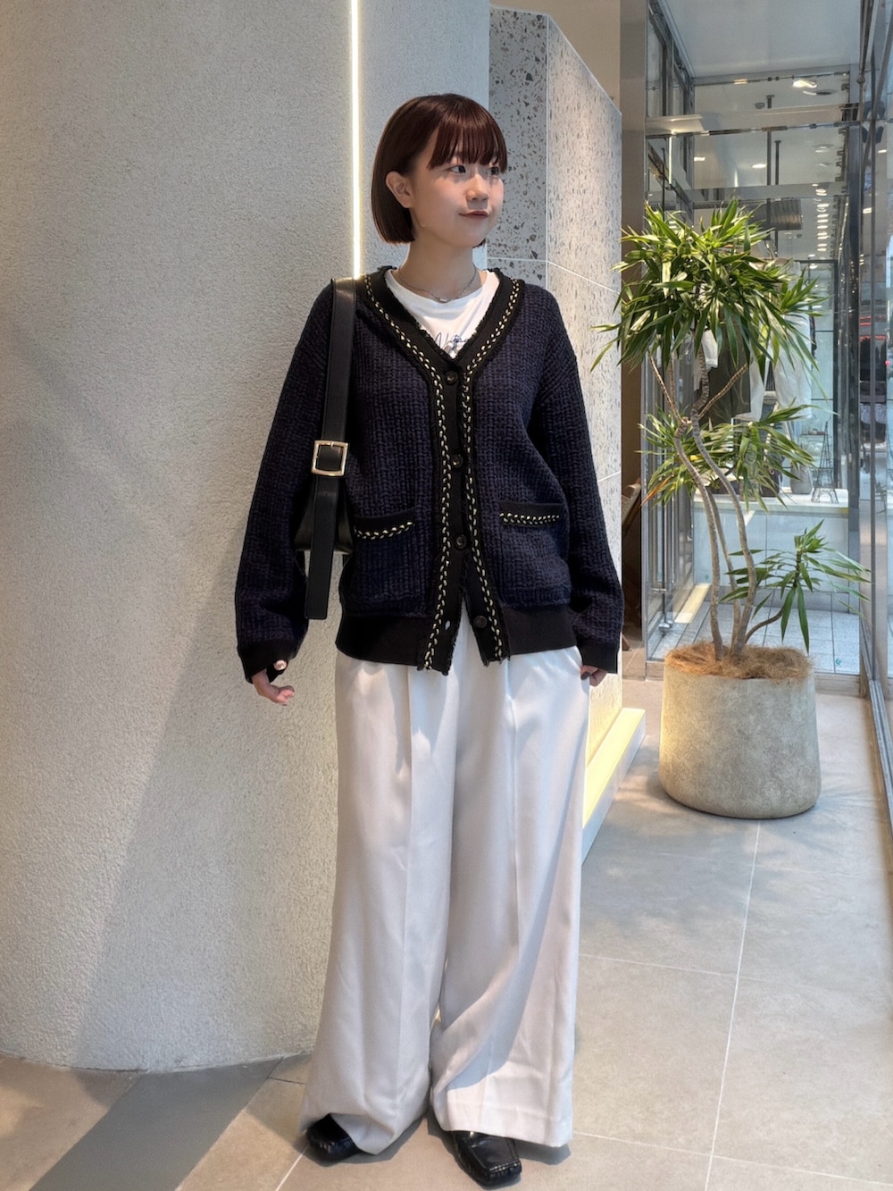 ホワイト系のTシャツ/カットソー、ブルー系のカーディガン/ボレロ、ブラック系のショルダーバッグを着用したレディースの秋コーディネートの5枚目の写真