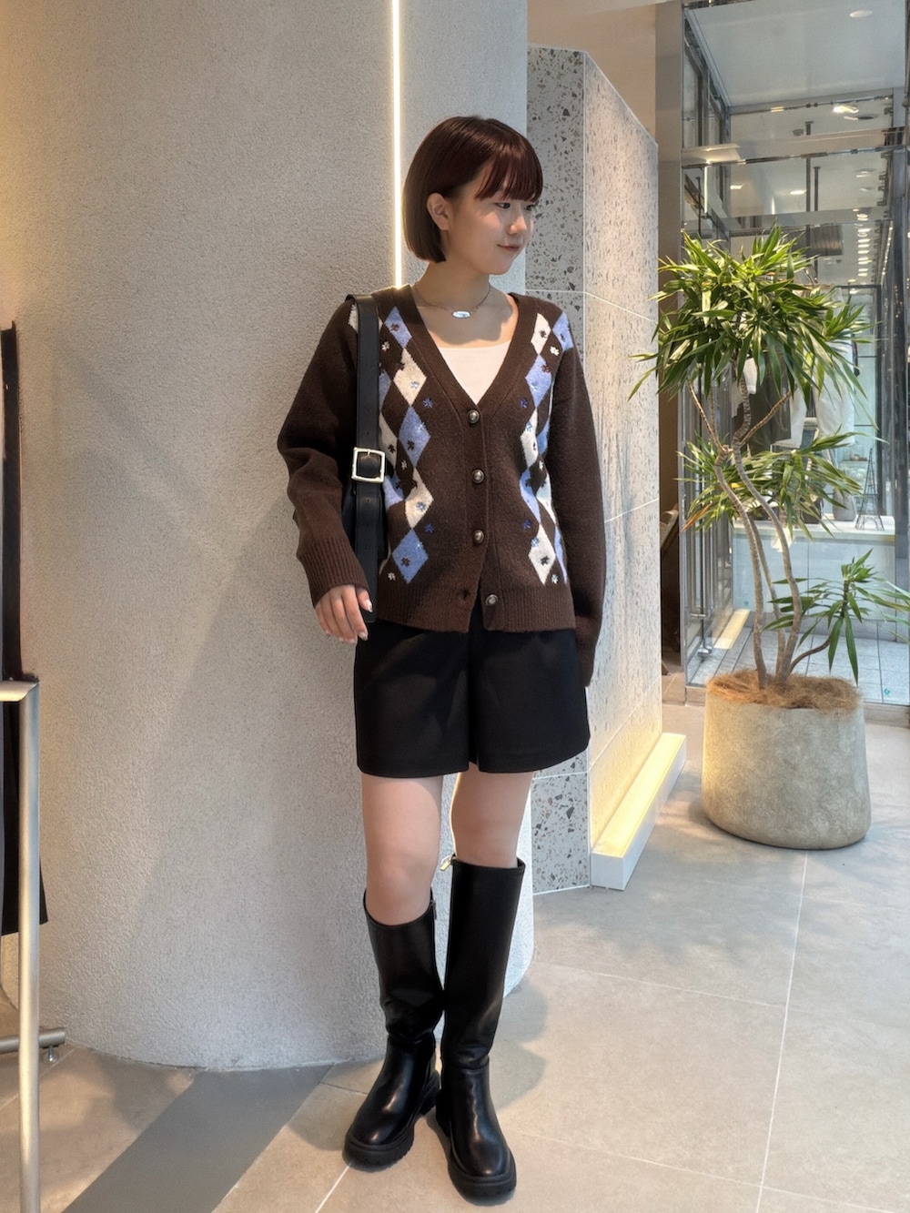 ブラウン系のカーディガン/ボレロ、ブラック系のショルダーバッグ、ブラック系のその他パンツを着用したレディースの秋コーディネートの5枚目の写真
