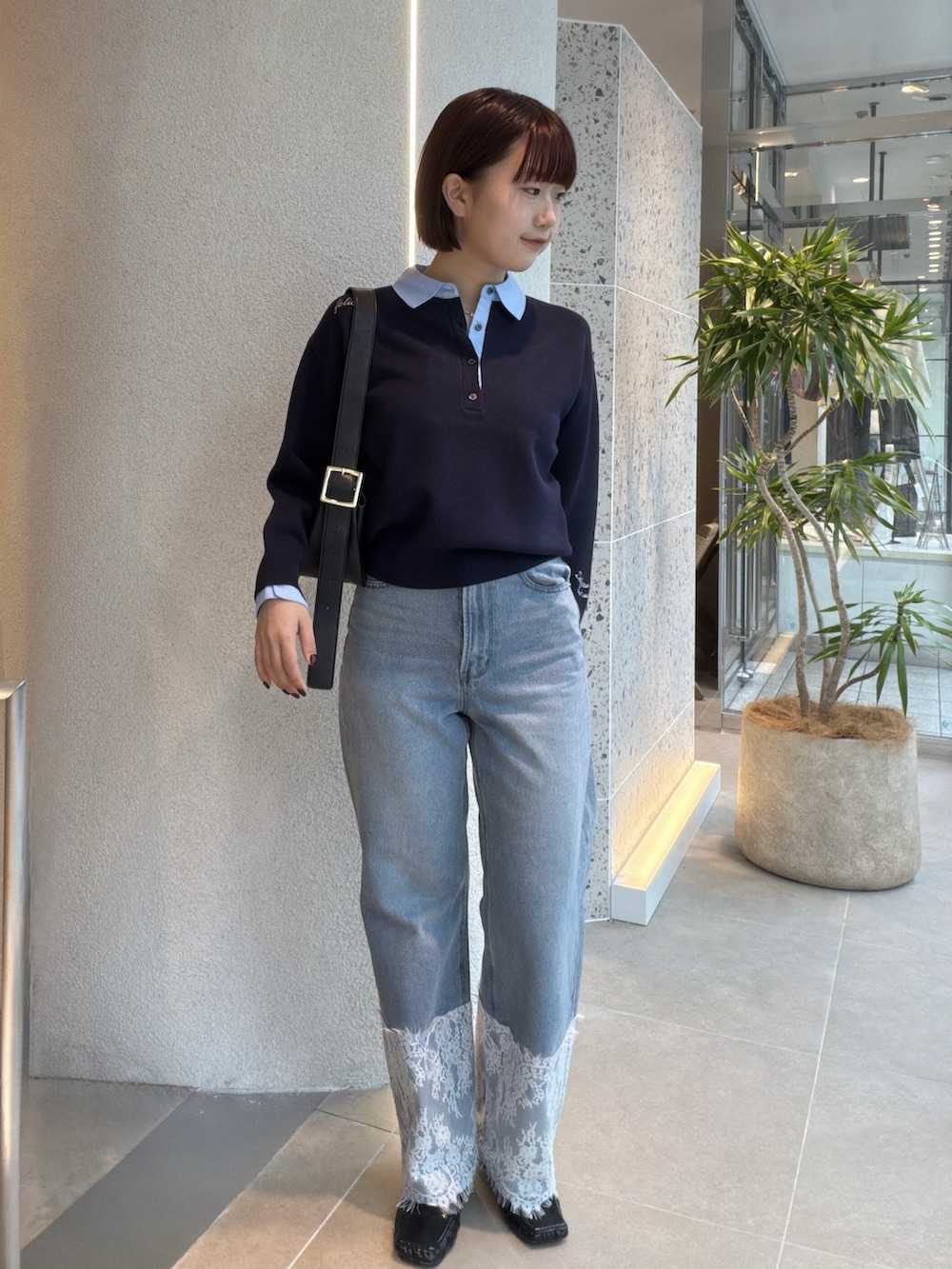ブルー系のニット/セーター、ブラック系のショルダーバッグ、ブルー系のデニムパンツを着用したレディースの秋コーディネートの6枚目の写真