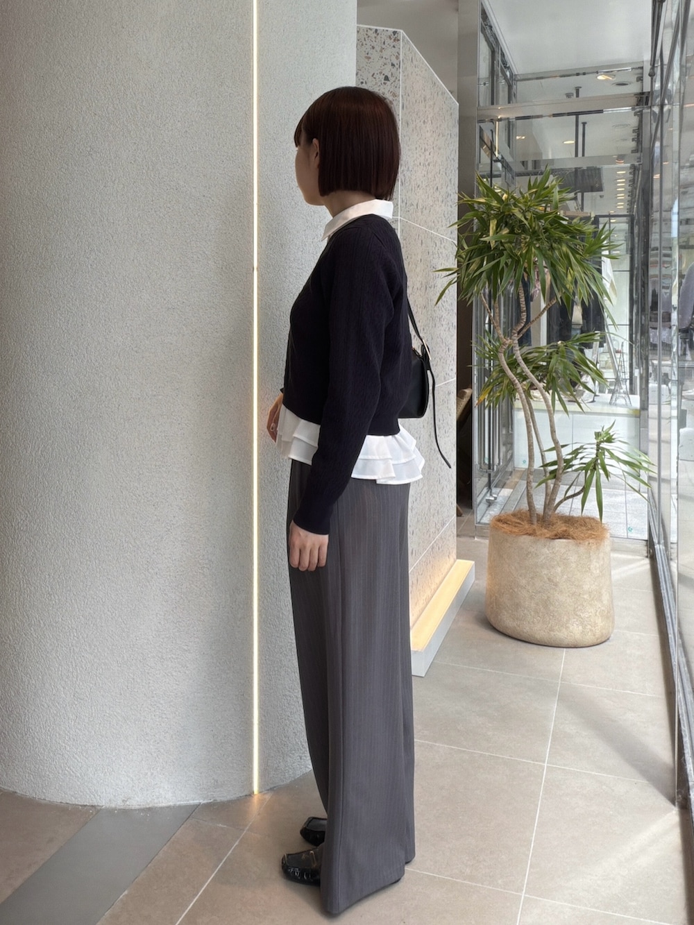 ホワイト系のシャツ/ブラウス、ブルー系のニット/セーター、ブラック系のショルダーバッグを着用したレディースの秋コーディネートの4枚目の写真
