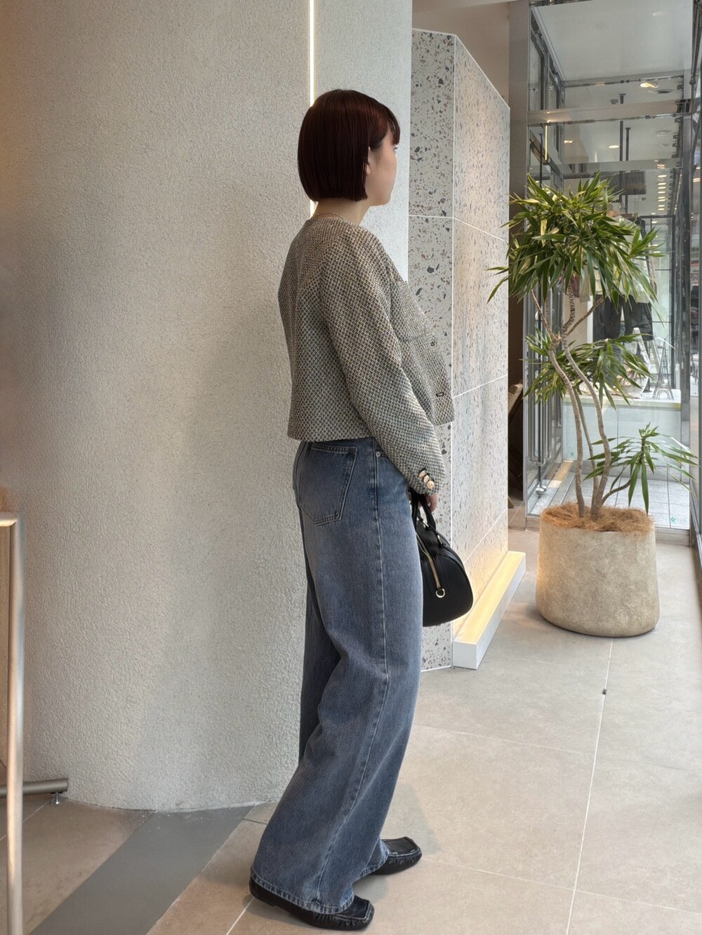 ブラック系のブルゾン、ホワイト系のTシャツ/カットソー、ブルー系のデニムパンツを着用したレディースの秋コーディネートの2枚目の写真