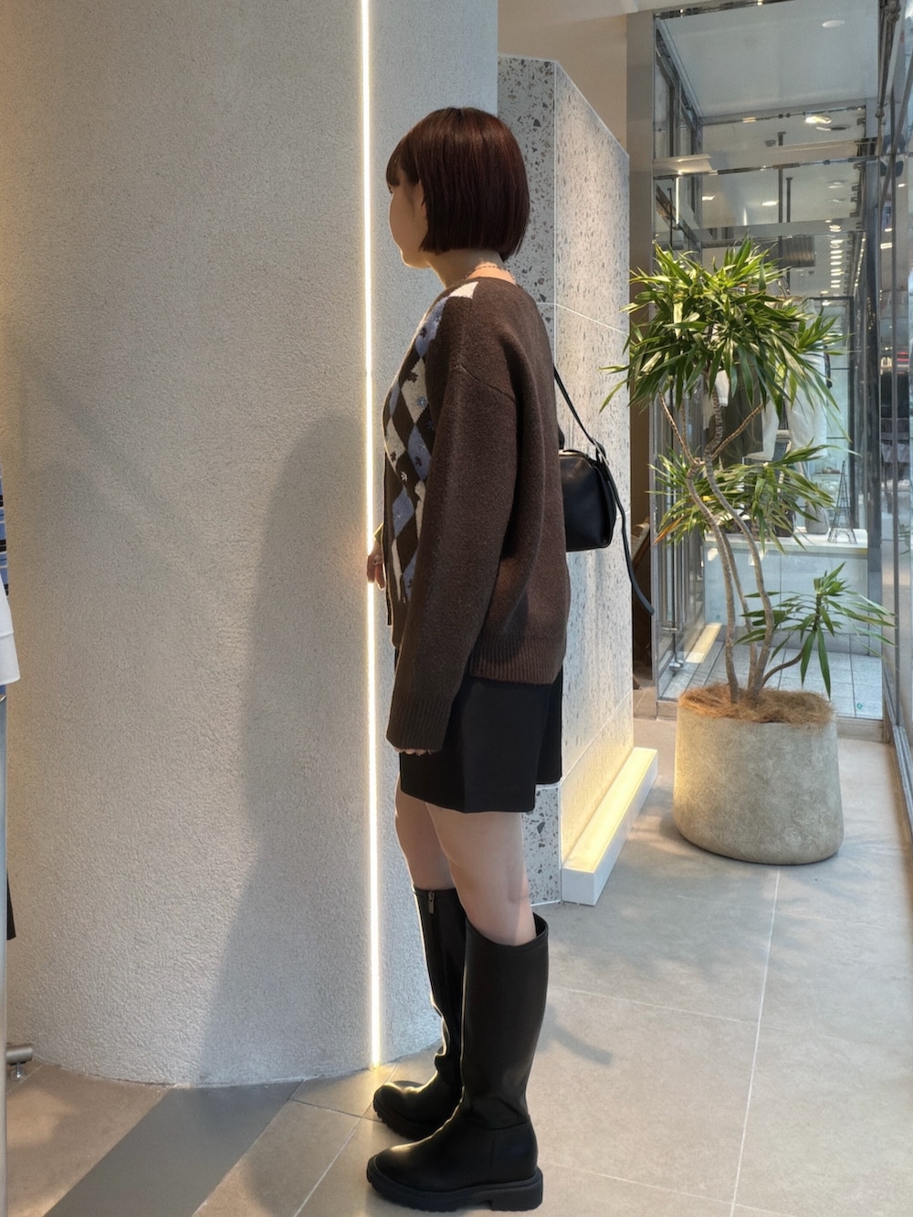 ブラウン系のカーディガン/ボレロ、ブラック系のショルダーバッグ、ブラック系のその他パンツを着用したレディースの秋コーディネートの4枚目の写真
