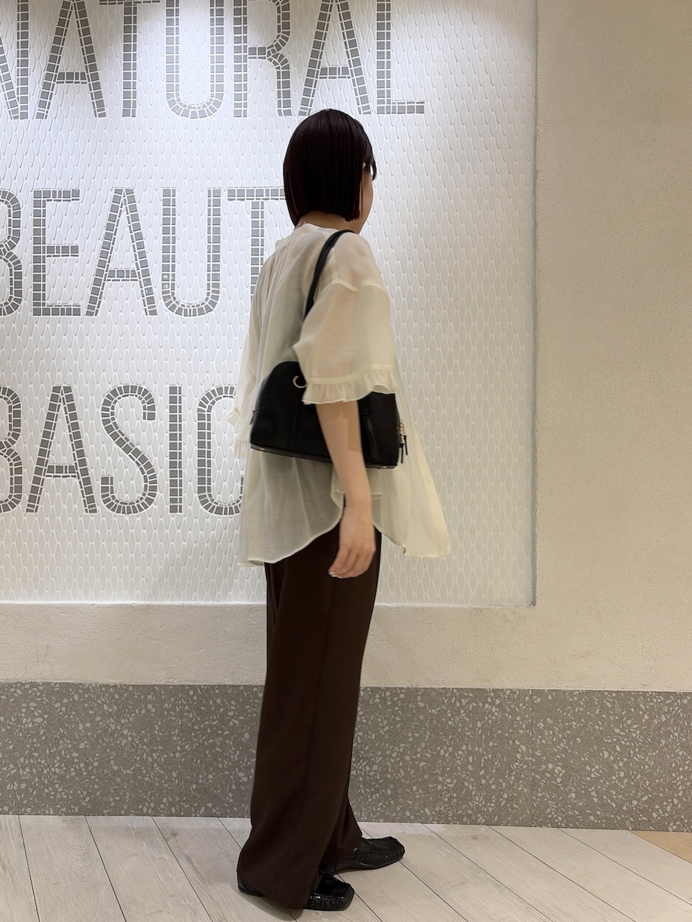ホワイト系のシャツ/ブラウス、ブラック系のボストンバッグ、ブラウン系のその他パンツを着用したレディースの夏コーディネートの2枚目の写真