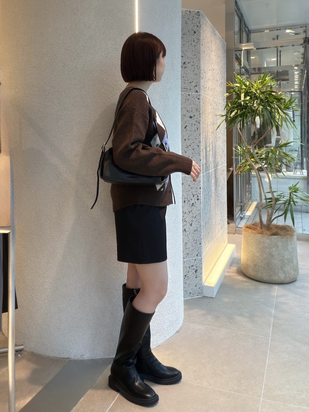 ブラウン系のカーディガン/ボレロ、ブラック系のショルダーバッグ、ブラック系のその他パンツを着用したレディースの秋コーディネートの2枚目の写真