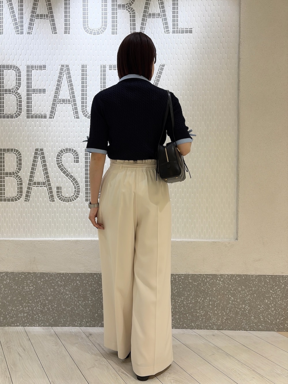 グレー系のニット/セーター、ブラック系のボストンバッグ、ホワイト系のその他パンツを着用したレディースの夏コーディネートの3枚目の写真