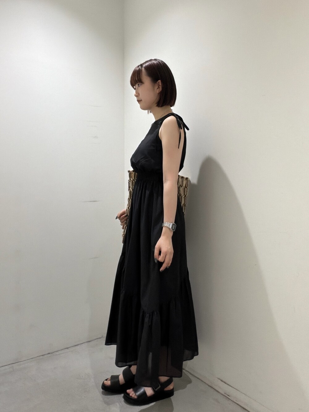 ブラック系のワンピース、ブラウン系のトートバッグ、ブラック系のサンダルを着用したレディースの夏コーディネートの4枚目の写真