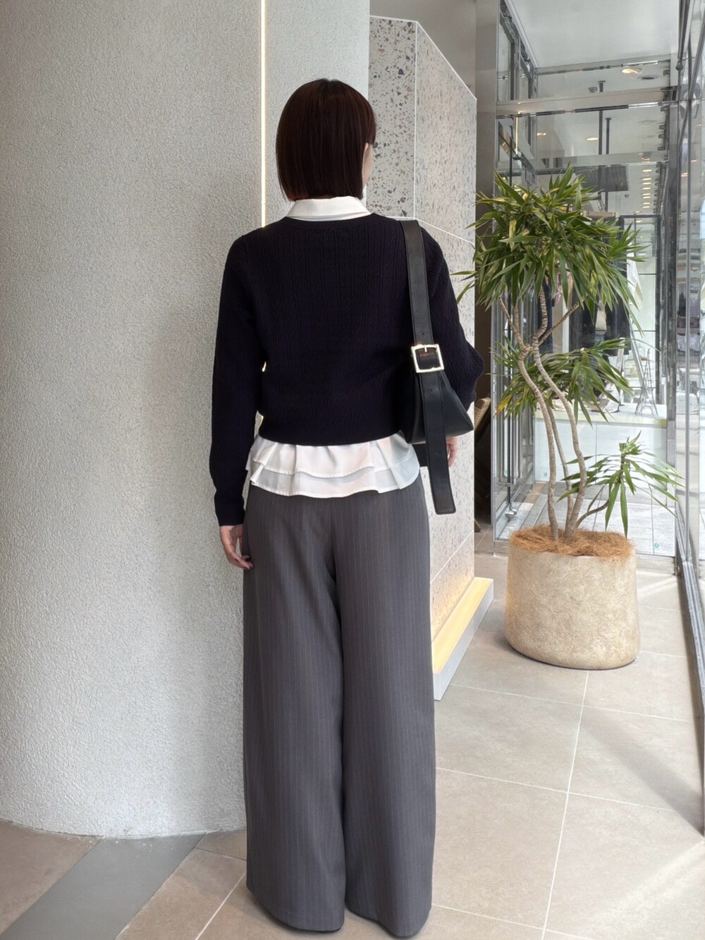 ホワイト系のシャツ/ブラウス、ブルー系のニット/セーター、ブラック系のショルダーバッグを着用したレディースの秋コーディネートの3枚目の写真
