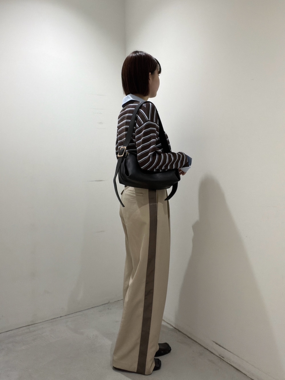 ブラウン系のニット/セーター、ブラック系のショルダーバッグ、ベージュ系のその他パンツを着用したレディースの夏コーディネートの2枚目の写真