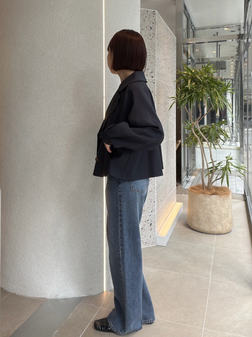 ブルー系のトレンチコート、ホワイト系のTシャツ/カットソー、ブルー系のデニムパンツを着用したレディースの秋コーディネートの4枚目の写真