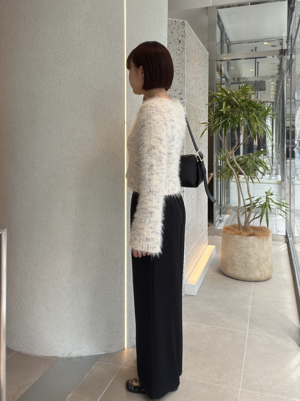 ホワイト系のカーディガン/ボレロ、ブラック系のショルダーバッグ、ブラック系のその他パンツを着用したレディースの秋コーディネートの4枚目の写真