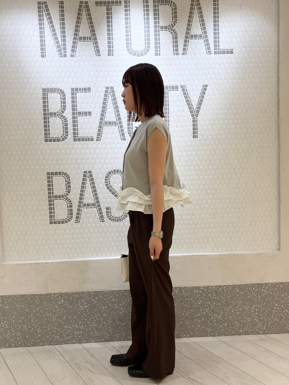 グレー系のベスト、ブラウン系のその他パンツ、ホワイト系のトートバッグを着用したレディースの夏コーディネートの4枚目の写真