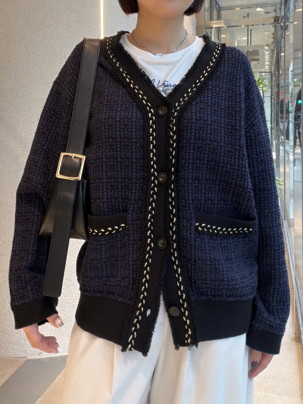 ホワイト系のTシャツ/カットソー、ブルー系のカーディガン/ボレロ、ブラック系のショルダーバッグを着用したレディースの秋コーディネートの6枚目の写真