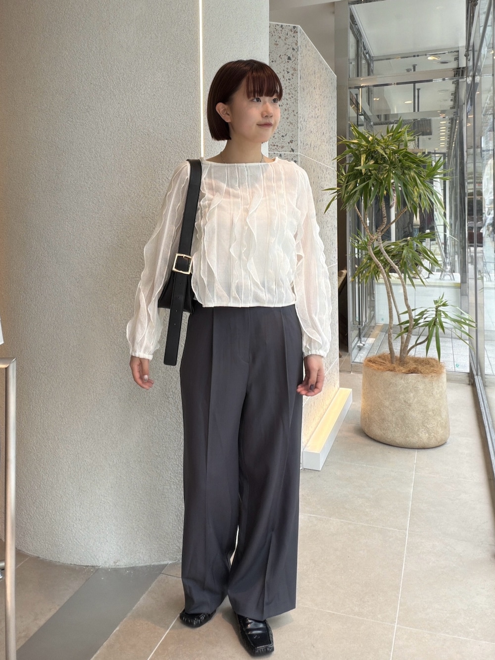 ホワイト系のTシャツ/カットソー、グレー系のその他パンツ、ブラック系のショルダーバッグを着用したレディースの秋コーディネートの5枚目の写真