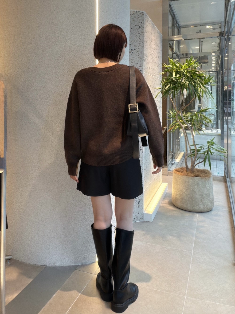 ブラウン系のカーディガン/ボレロ、ブラック系のショルダーバッグ、ブラック系のその他パンツを着用したレディースの秋コーディネートの3枚目の写真