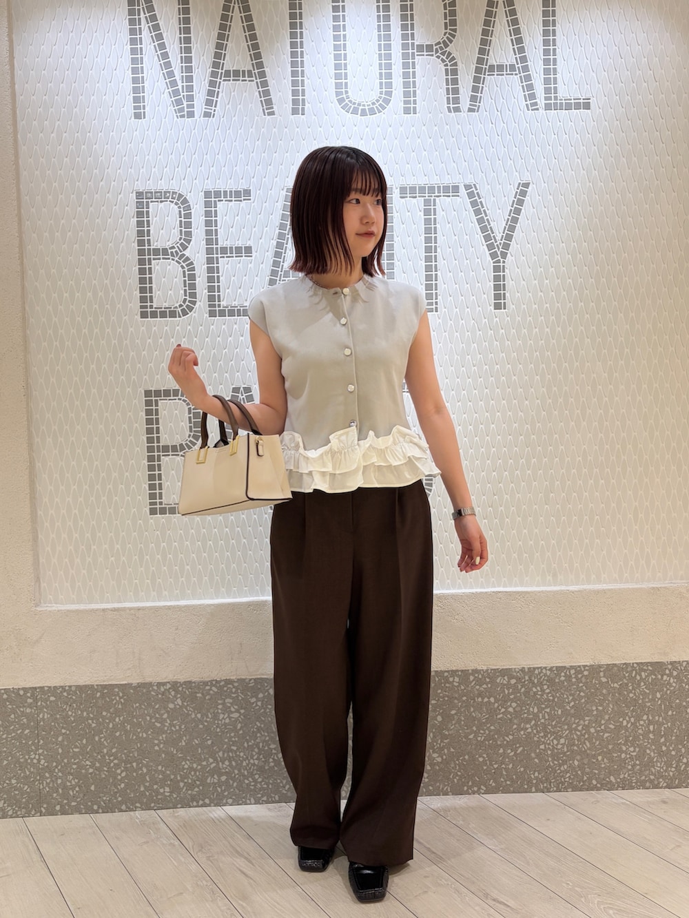 グレー系のベスト、ブラウン系のその他パンツ、ホワイト系のトートバッグを着用したレディースの夏コーディネートの5枚目の写真