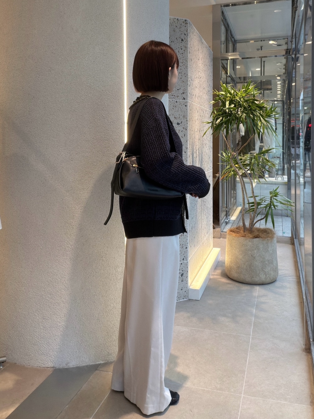ホワイト系のTシャツ/カットソー、ブルー系のカーディガン/ボレロ、ブラック系のショルダーバッグを着用したレディースの秋コーディネートの2枚目の写真