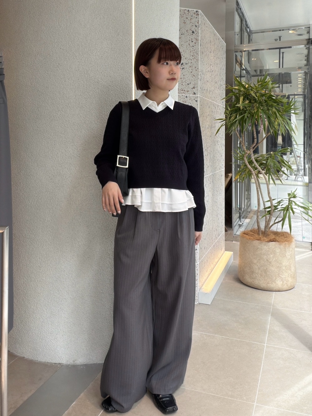 ホワイト系のシャツ/ブラウス、ブルー系のニット/セーター、ブラック系のショルダーバッグを着用したレディースの秋コーディネートの5枚目の写真