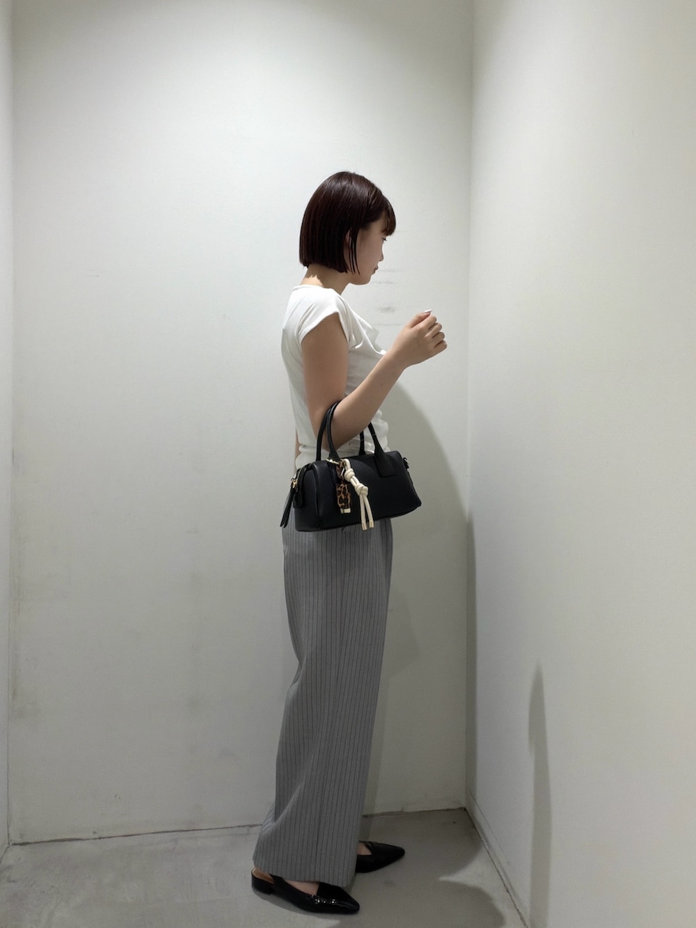 ホワイト系のTシャツ/カットソー、ブラック系のボストンバッグ、グレー系のその他パンツを着用したレディースの夏コーディネートの2枚目の写真
