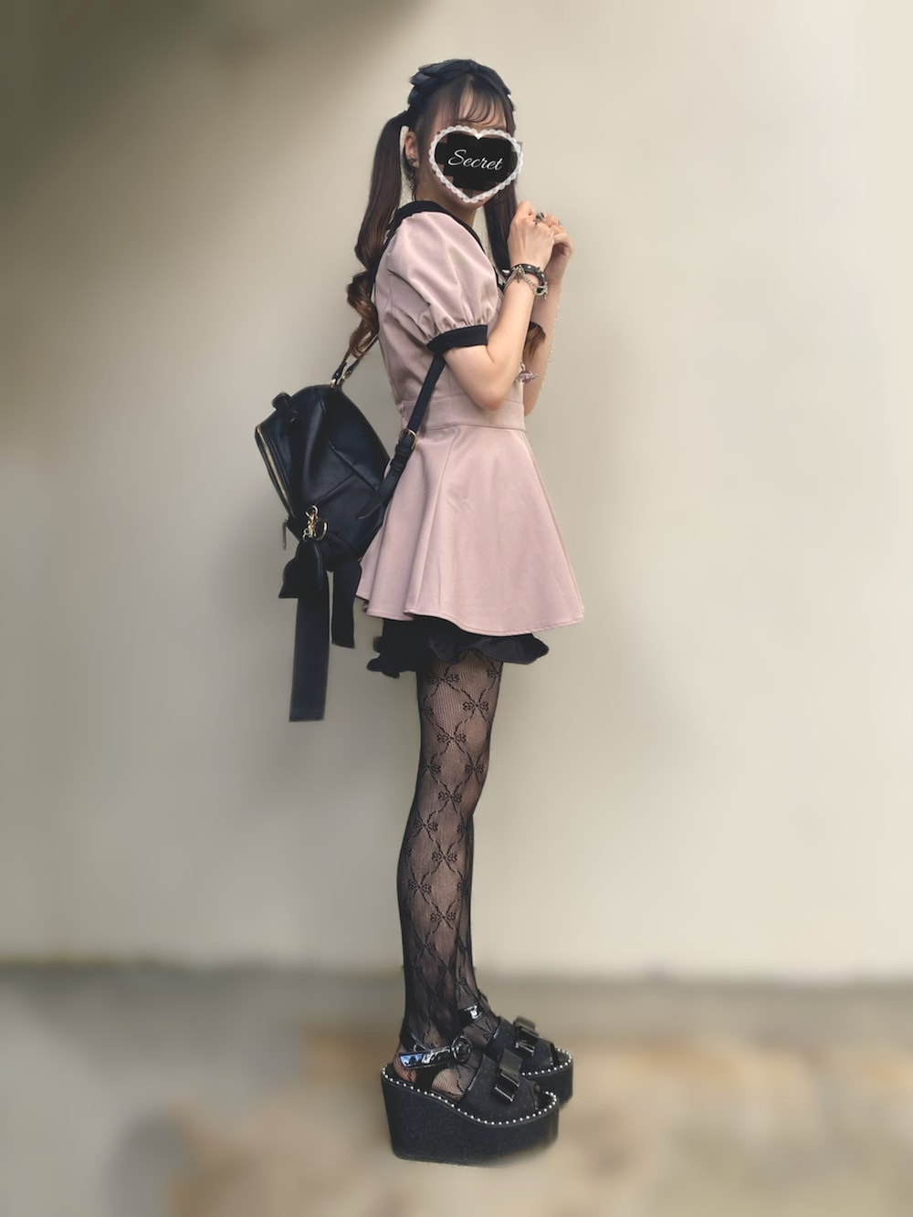 ピンク系のセットアップ、ブラック系のサンダル、ブラック系のバックパック/リュックを着用したレディースの秋コーディネートの2枚目の写真