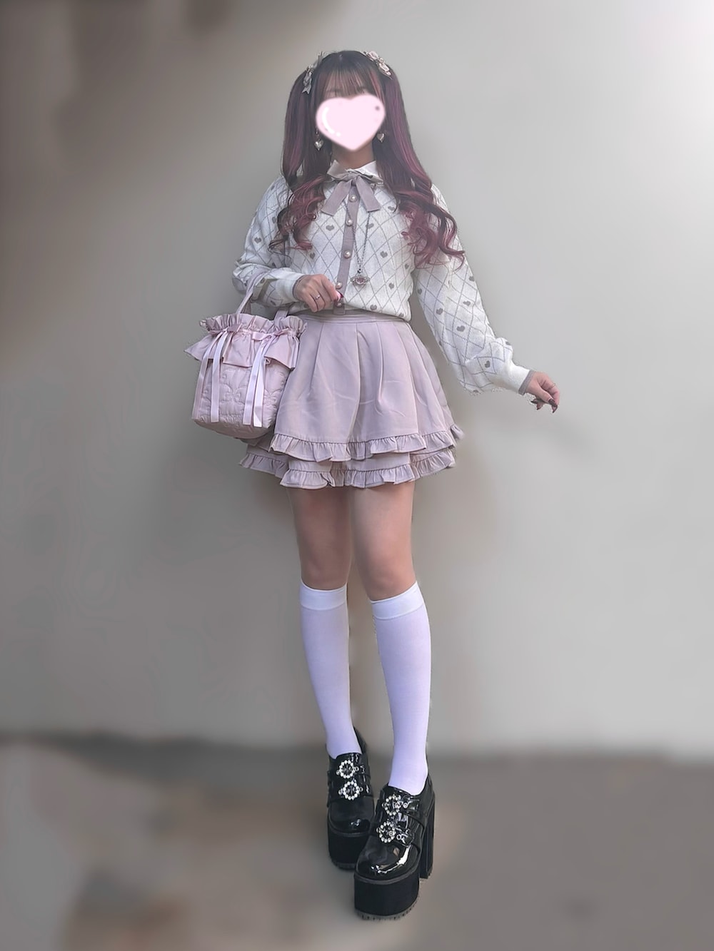 ピンク系のニット/セーター、ピンク系のスカート、ブラック系のパンプスを着用したレディースの秋コーディネートの3枚目の写真