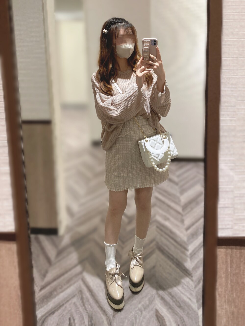 ピンク系のニット/セーター、ベージュ系のスカート、ホワイト系のショルダーバッグを着用したレディースの秋コーディネートの2枚目の写真