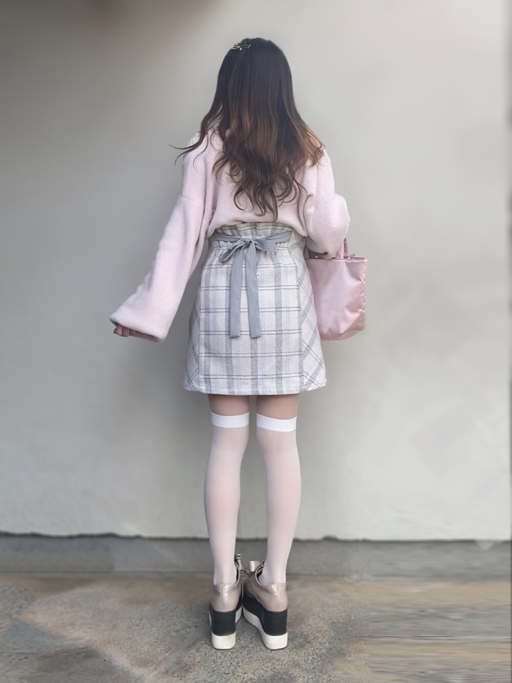 ピンク系のカーディガン/ボレロ、ベージュ系のスカート、ピンク系のトートバッグを着用したレディースの冬コーディネートの2枚目の写真