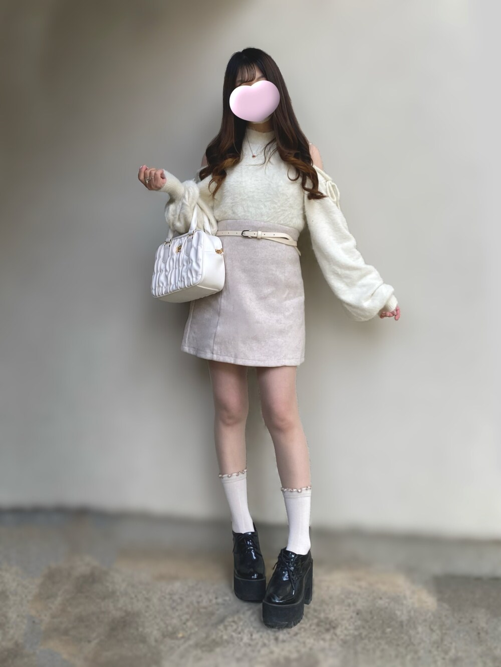 ホワイト系のニット/セーター、ホワイト系のスカート、ホワイト系のボストンバッグを着用したレディースの秋コーディネートの2枚目の写真