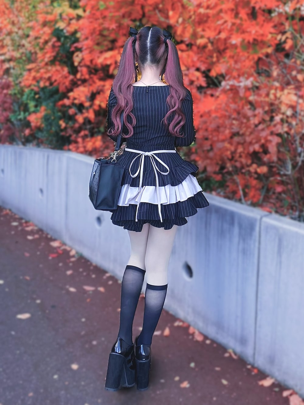 ブラック系のパンプス、ブラック系のセットアップ、ブラック系のショルダーバッグを着用したレディースの秋コーディネートの4枚目の写真