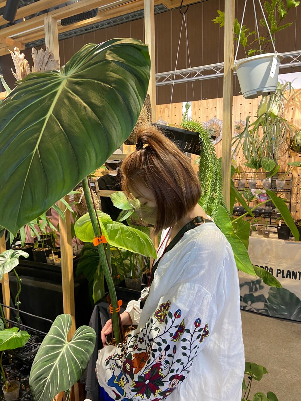 ブラウン系のバッグ、ホワイト系のトップス、ホワイト系のデニムパンツを着用したレディースの秋コーディネートの2枚目の写真