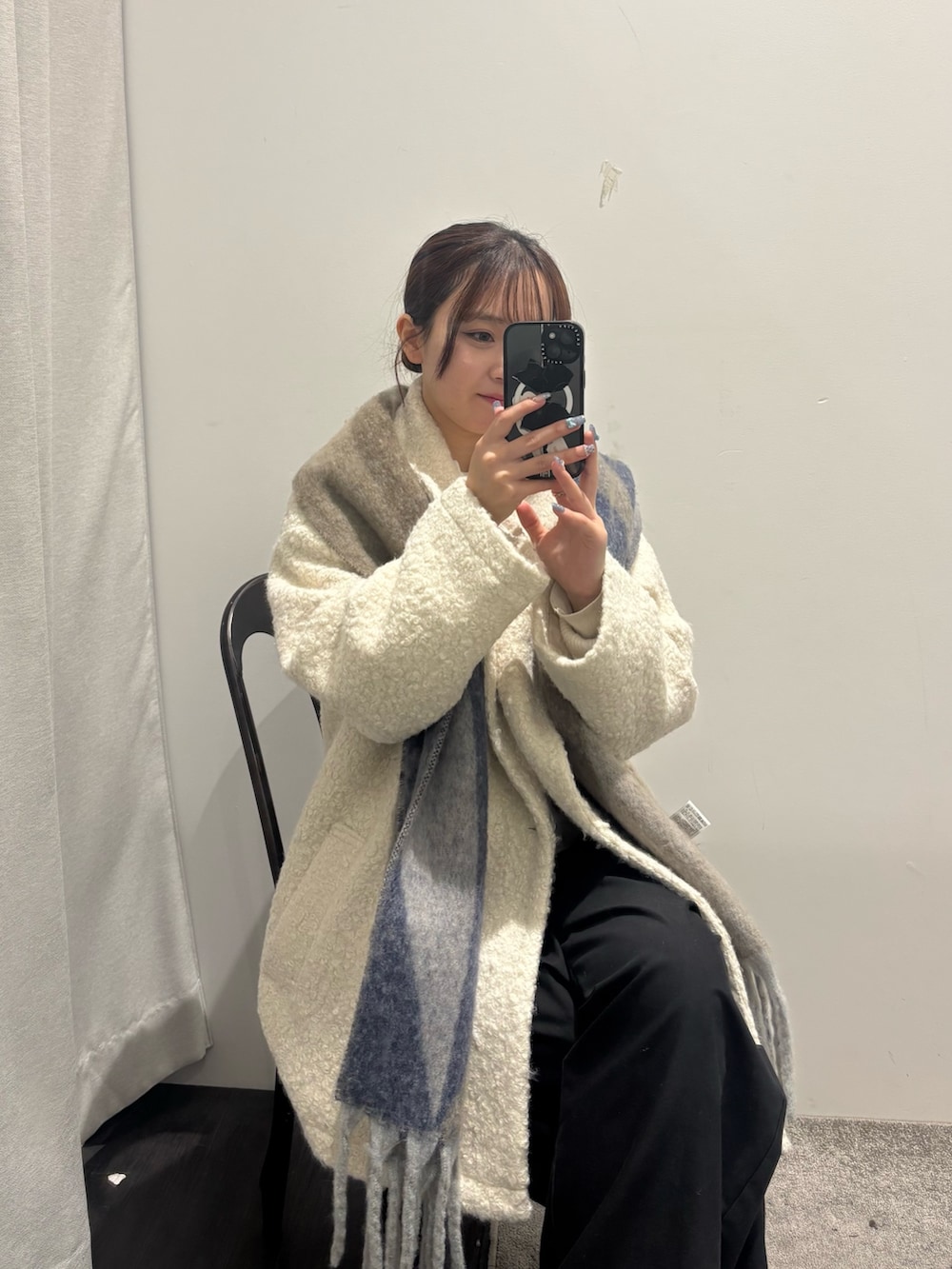 ホワイト系のピーコート、ブラウン系のマフラーを着用したレディースの秋コーディネートの3枚目の写真