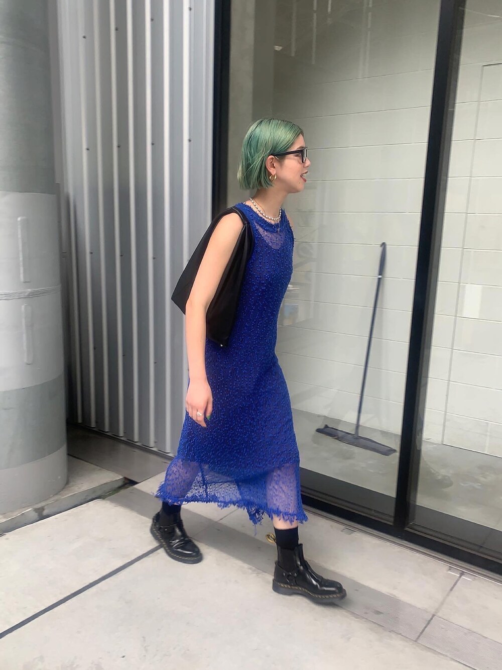 ブルー系のワンピース、ブラック系のハンドバッグを着用したレディースの夏コーディネートの2枚目の写真