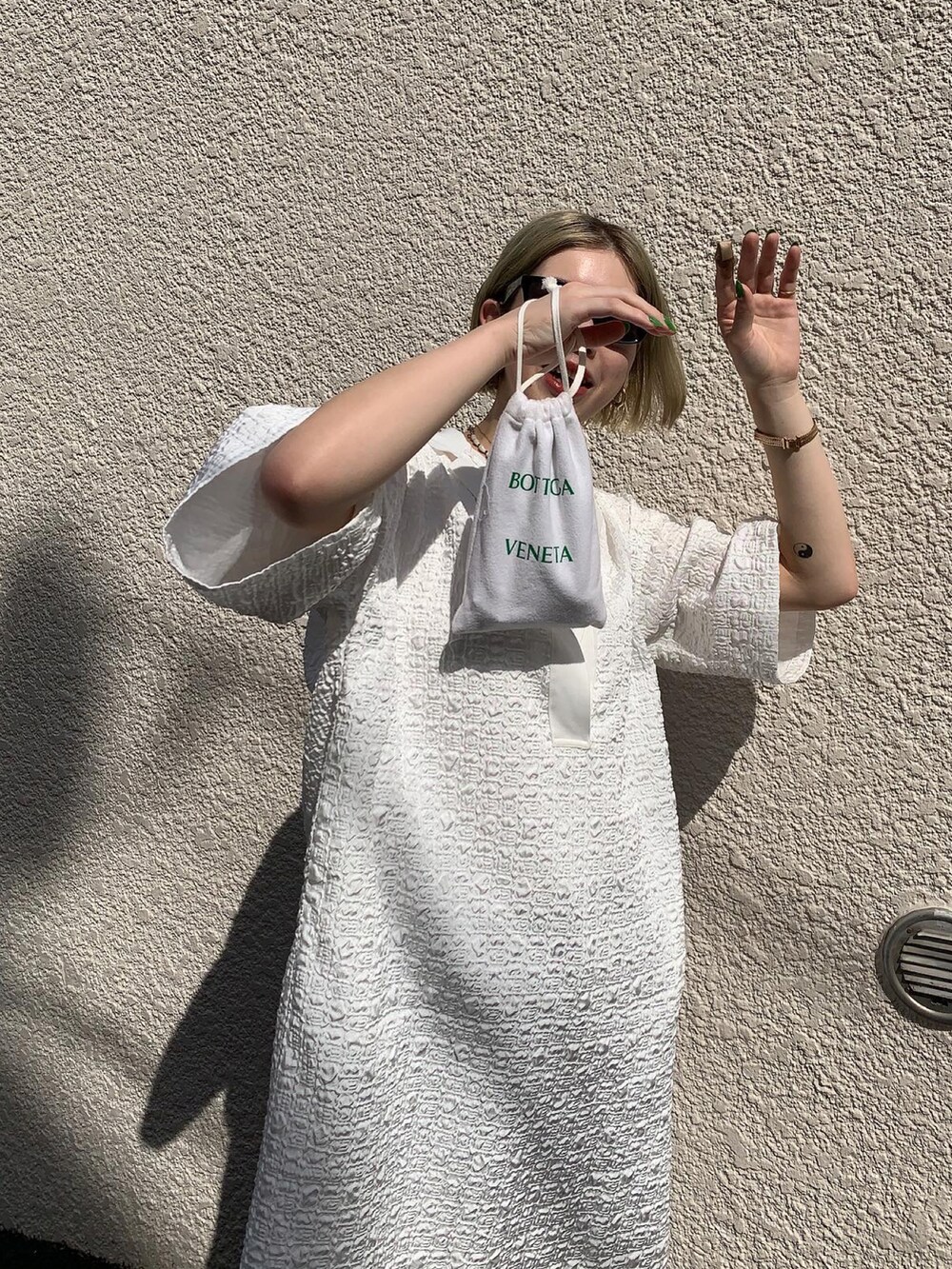 ホワイト系のワンピース、ブルー系のデニムパンツ、ベージュ系のサンダルを着用したレディースの夏コーディネートの3枚目の写真