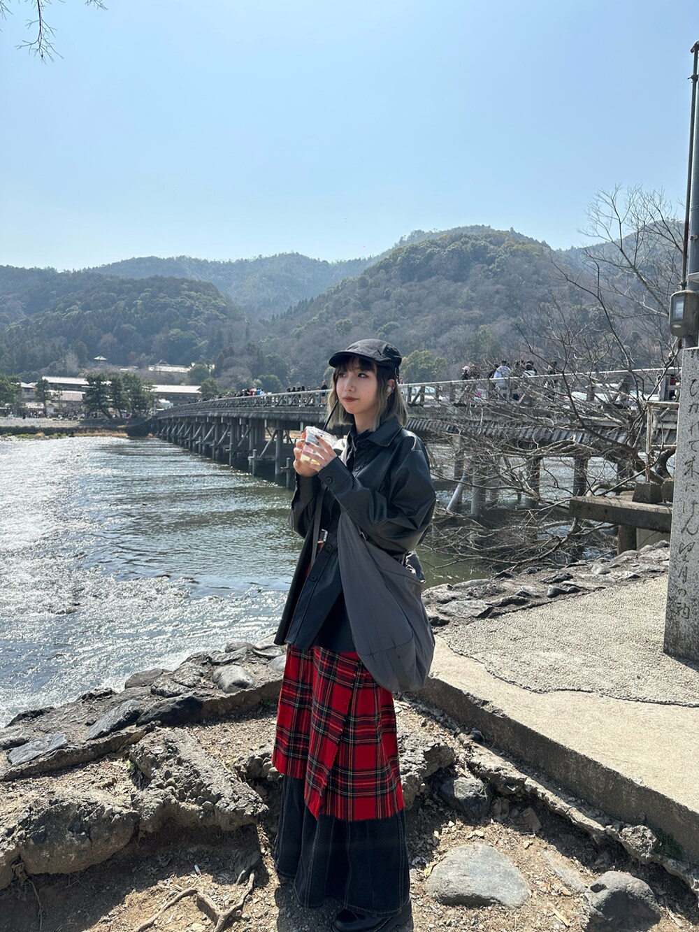 ブラック系のその他アウター、レッド系のスカート、ブラック系のローファーを着用したレディースの春コーディネートの2枚目の写真