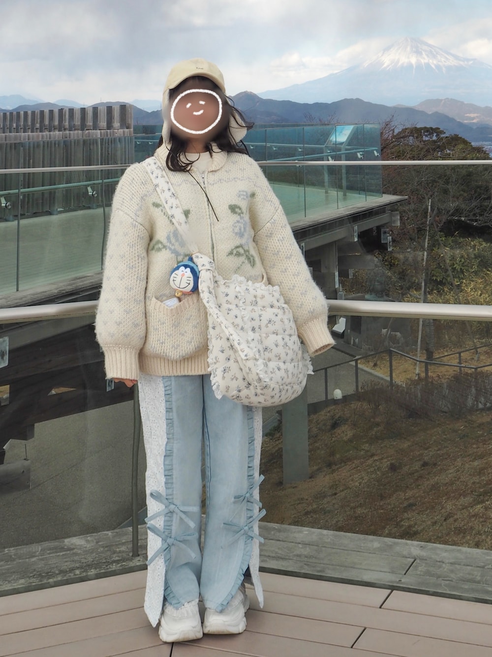 ブルー系のカーディガン/ボレロ、ブルー系のショルダーバッグ、ブルー系のデニムパンツを着用したレディースの冬コーディネートの2枚目の写真