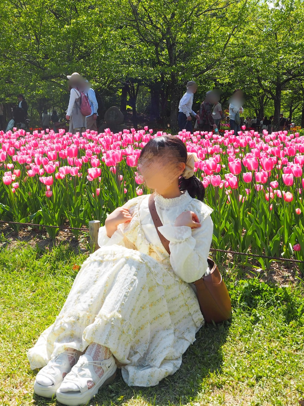 イエロー系のワンピース、ブラウン系のショルダーバッグ、ベージュ系のサンダルを着用したレディースの春コーディネートの2枚目の写真