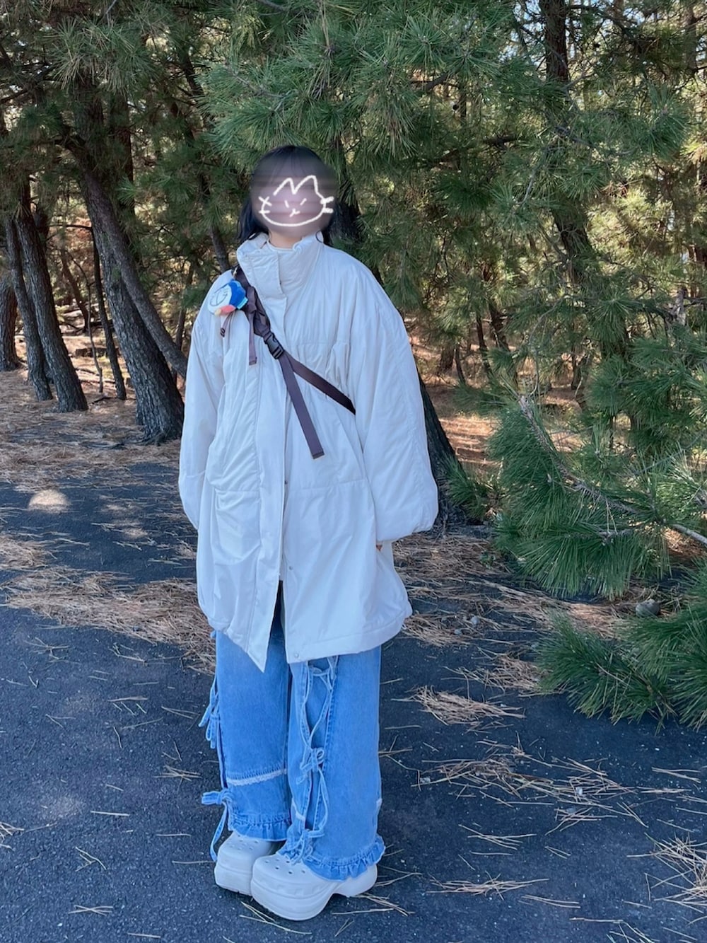 ホワイト系のサンダル、ホワイト系のブルゾン、ブラウン系のショルダーバッグを着用したレディースの冬コーディネートの2枚目の写真