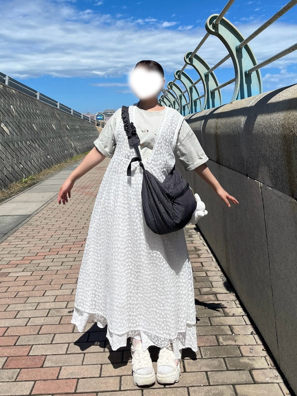 グレー系のハンドバッグ、ベージュ系のサンダル、グリーン系のTシャツ/カットソーを着用したレディースの秋コーディネートの2枚目の写真