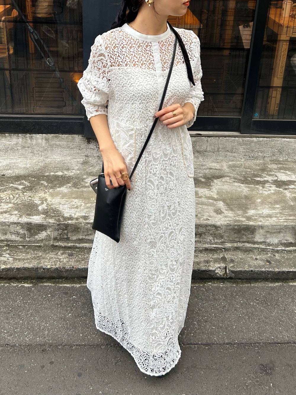 ホワイト系のワンピース、ブラック系のバッグを着用したレディースの秋コーディネートの2枚目の写真