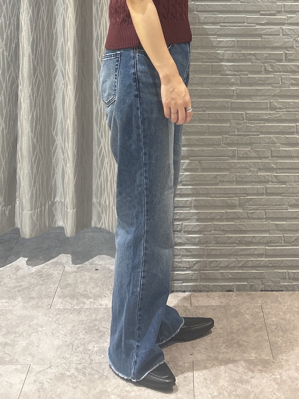 レッド系のニット/セーター、ブルー系のデニムパンツ、ブラック系のパンプスを着用したレディースの秋コーディネートの8枚目の写真
