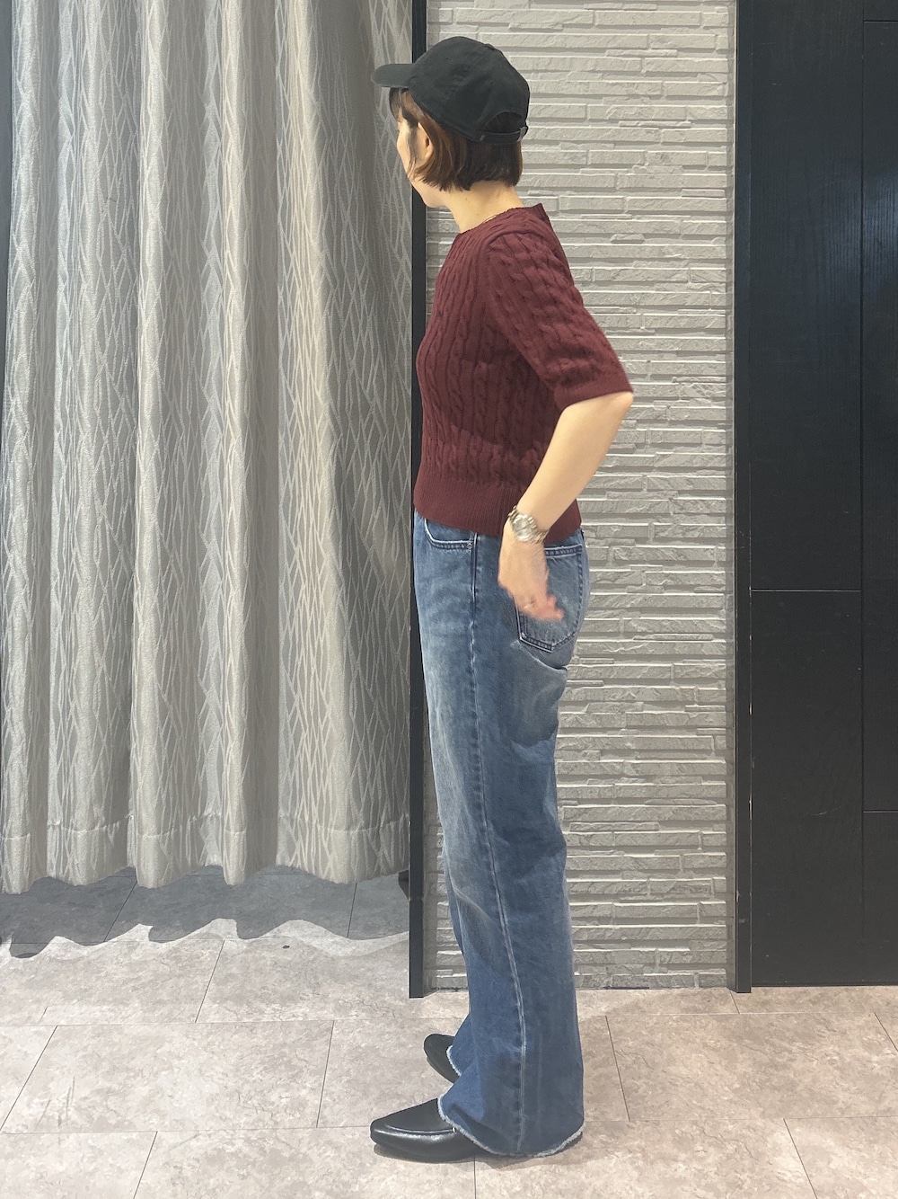 レッド系のニット/セーター、ブルー系のデニムパンツ、ブラック系のパンプスを着用したレディースの秋コーディネートの3枚目の写真